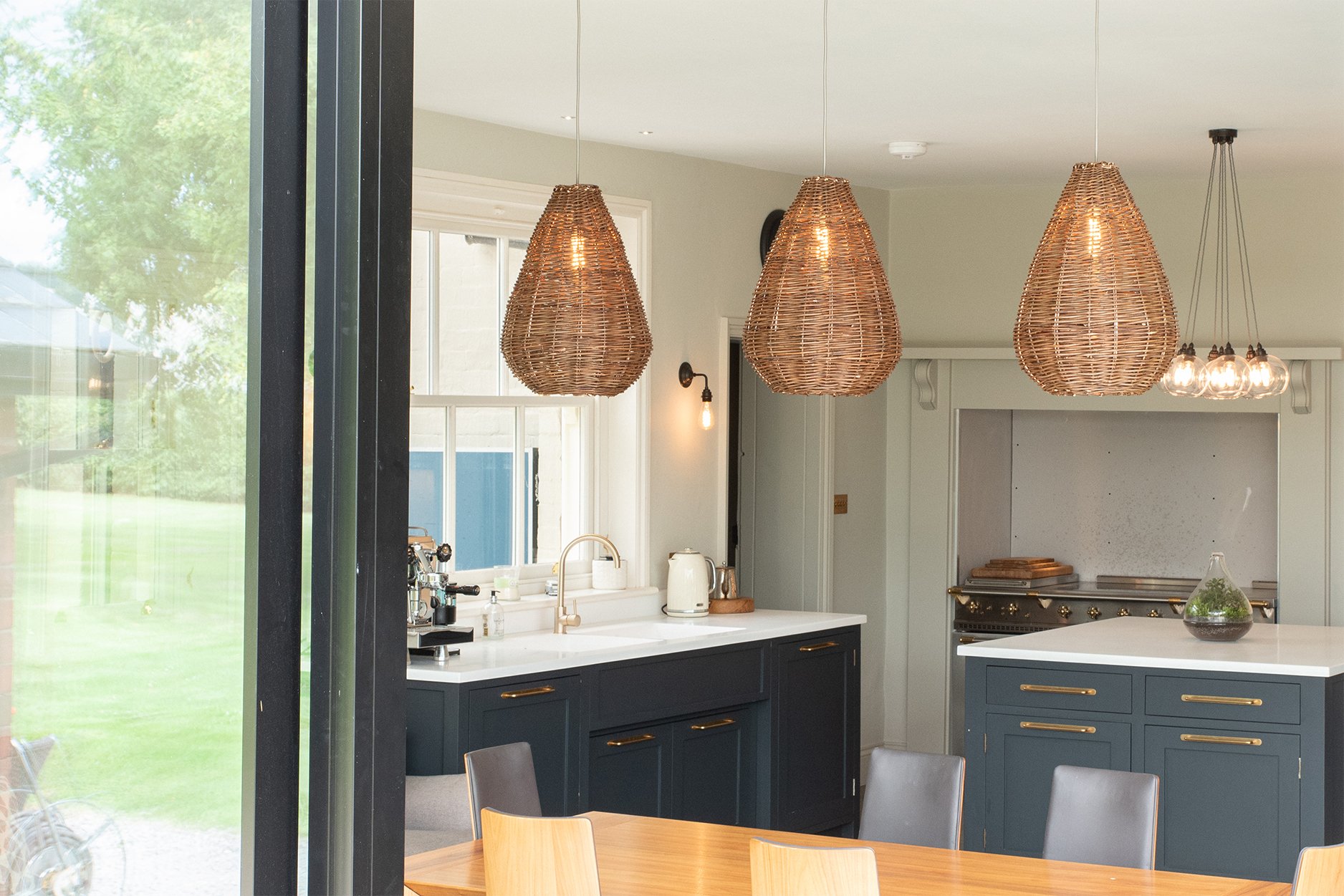 Three hand-woven wicker shades crafted from willow adding a perfect earthy touch to the kitchen. Part of the Wicker Lighting Collection, these shades bring natural elegance to any setting.