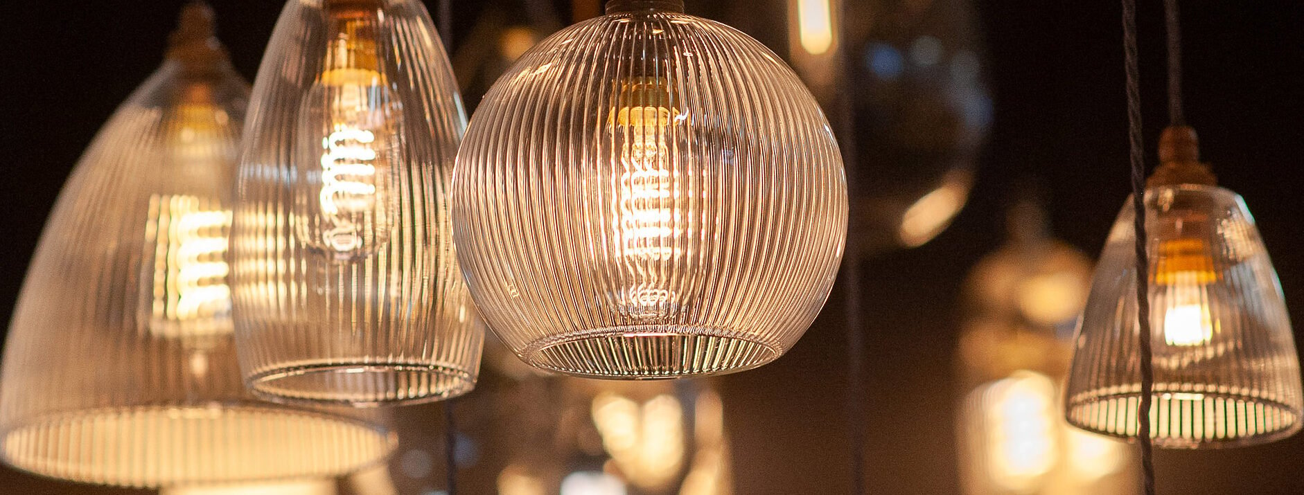 Fritz Fryer's various pendant glass lights brightening a room with its welcoming glow.