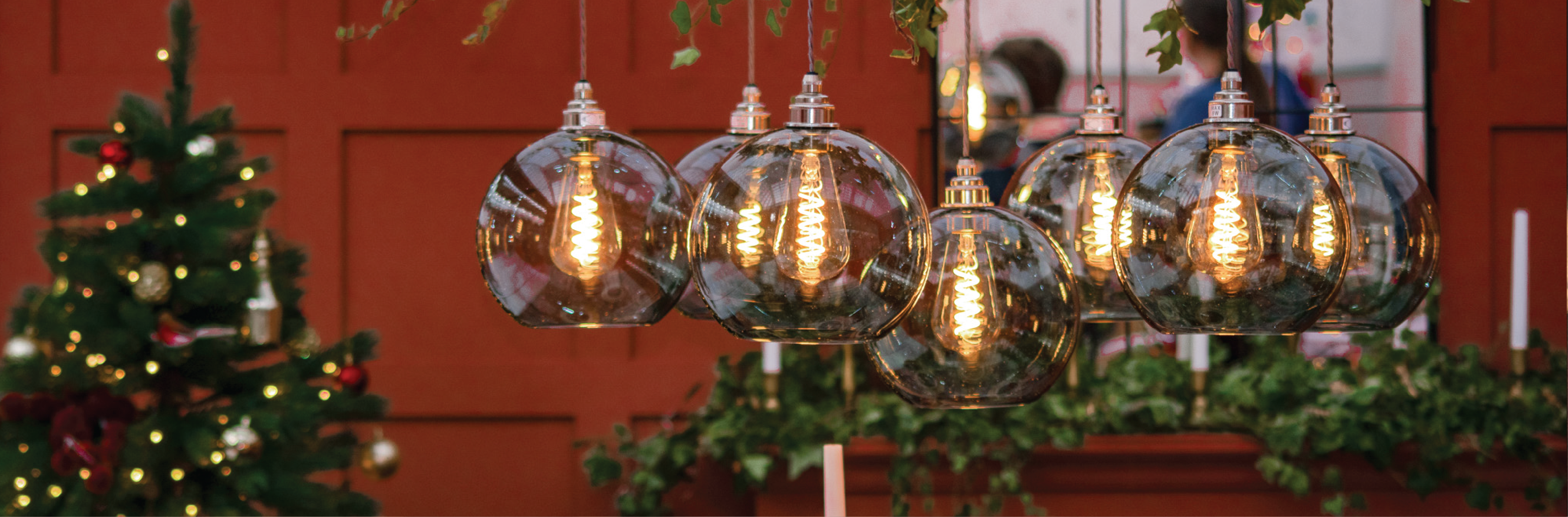 Christmas lighting by Fritz Fryer, with pendant lights hung by a Christmas tree in a dining room