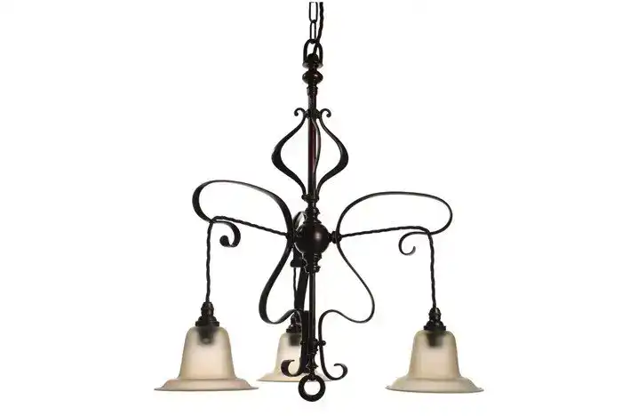 Antique black wrought iron chandelier with three glass lampshades, hanging from a chain.