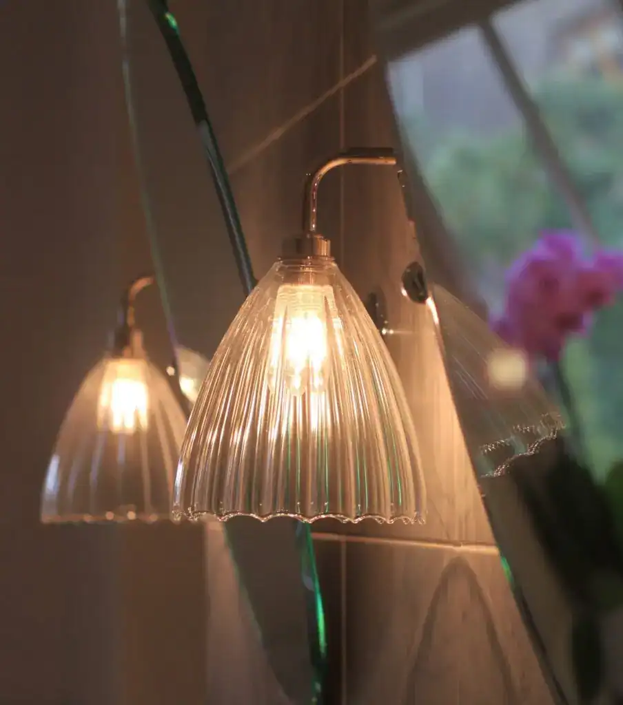 Elegant glass wall light with a ribbed design, providing warm ambient lighting for interior spaces.