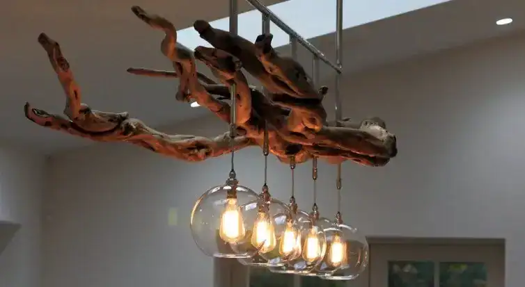 Modern wooden branch chandelier with exposed bulbs in a contemporary interior.