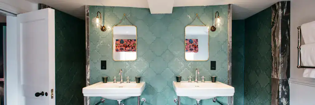 Elegant bathroom with dual sinks and stylish wall-mounted lighting fixtures.