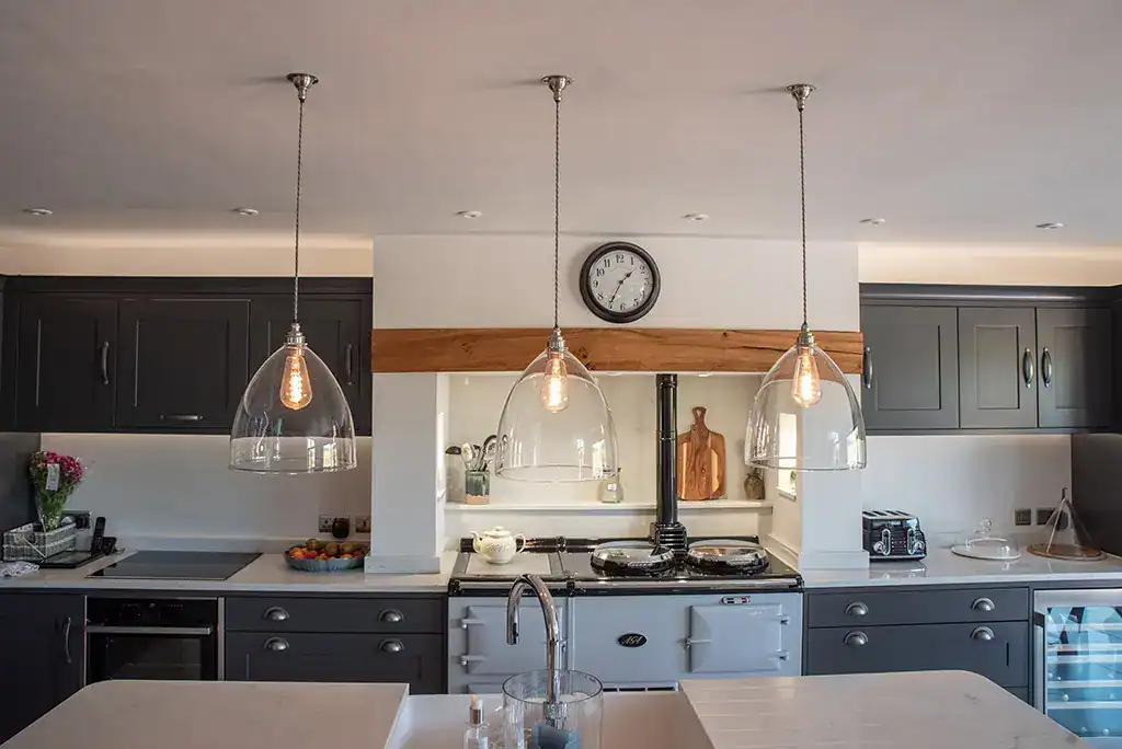Pendant lighting over kitchen island with glass shades and Edison bulbs.