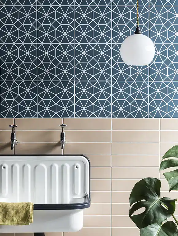 Modern kitchen with geometric blue wall tiles and a white pendant light.