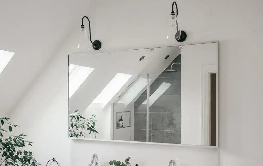 Modern bathroom mirror with integrated lighting and black wall-mounted lamps.