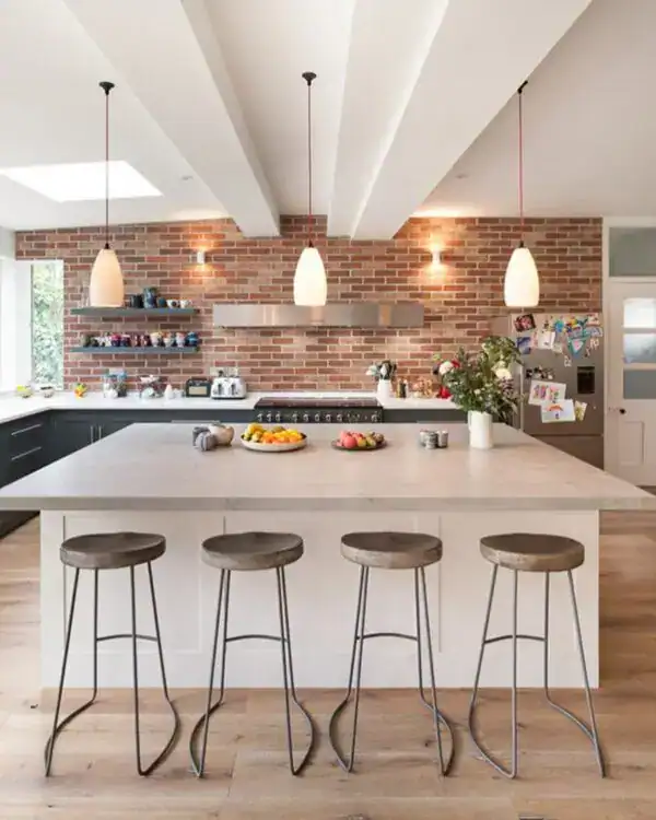 Modern kitchen island with pendant lighting and brick wall backdrop.