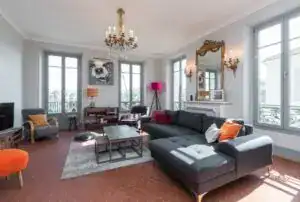 Spacious living room featuring large windows, stylish furniture, and contemporary lighting fixtures.