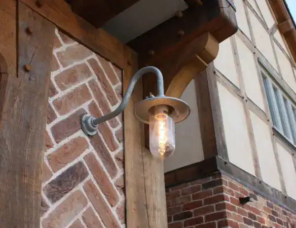Vintage outdoor wall light with exposed filament bulb.