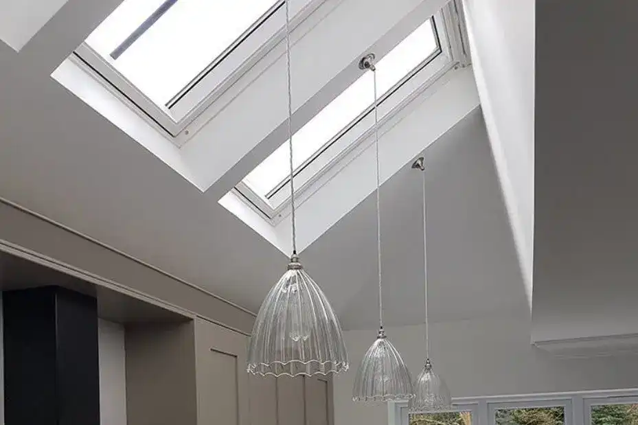 Skylight ceiling with three hanging pendant lights in a contemporary interior.