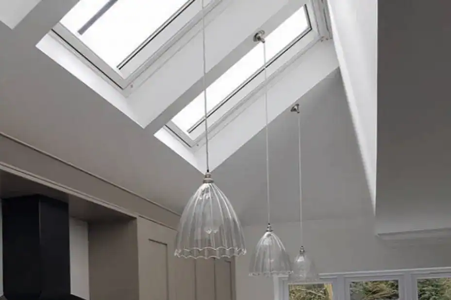 Pendant lights hanging beneath a large skylight in a contemporary interior.