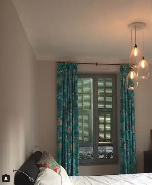 Elegant bedroom with colourful curtains and modern pendant lights.