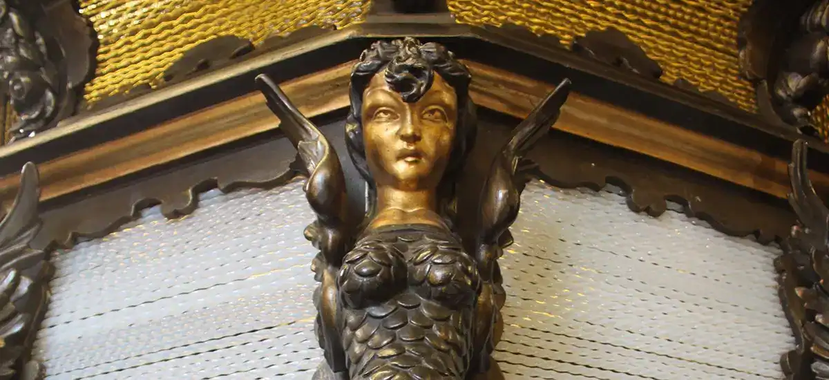 Ornate decorative sculpture of a mermaid figure with intricate detailing.