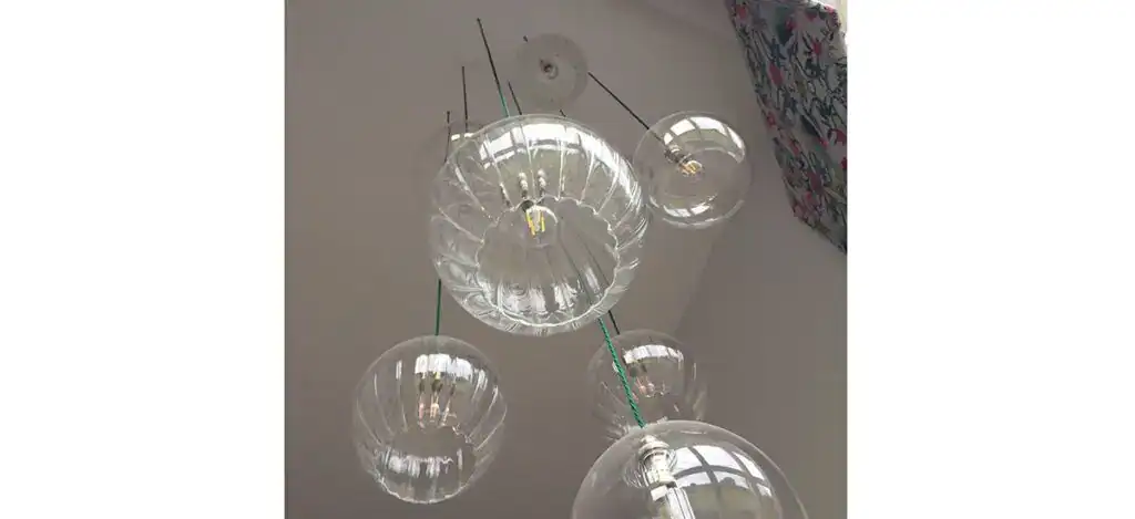 Modern glass pendant lighting fixture with multiple spherical glass shades.