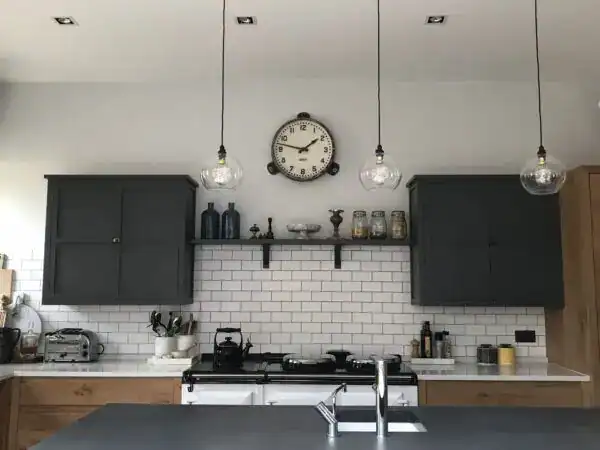 Modern kitchen with black cabinetry and pendant lighting fixtures.