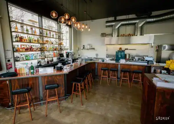 Stylish bar area with modern lighting and a well-stocked liquor shelf in a contemporary restaurant s.