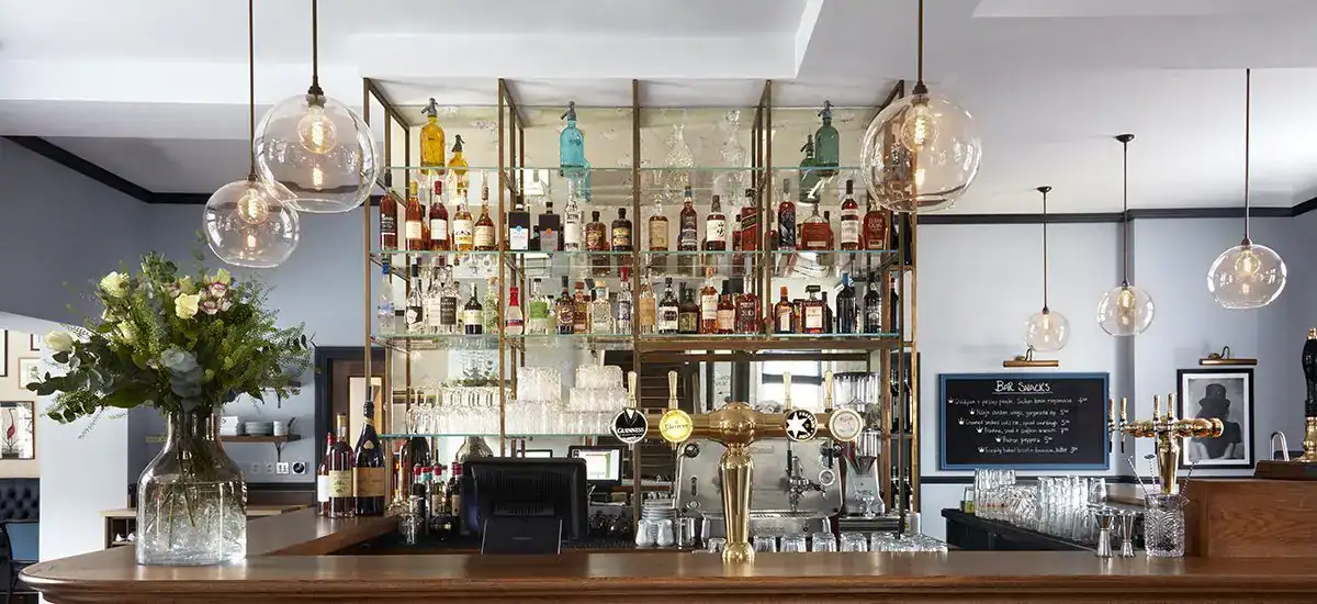 Elegant bar with modern lighting fixtures and a well-stocked liquor display.