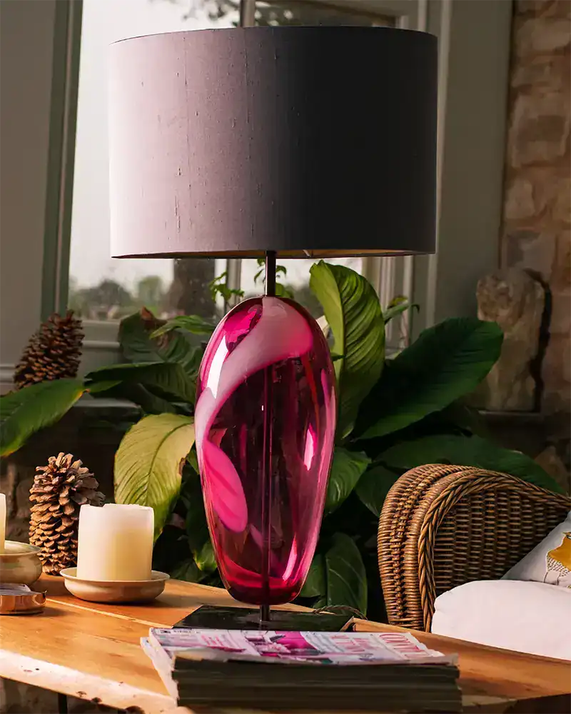 Elegant pink glass table lamp with grey lampshade.