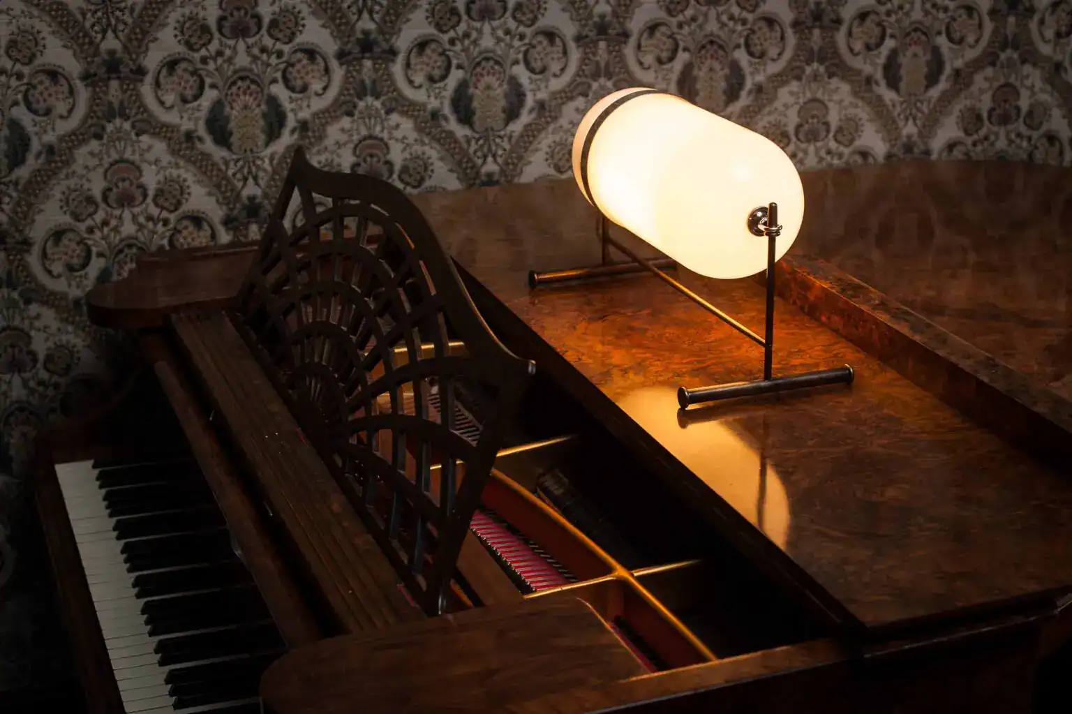 Elegant piano with modern lighting in a vintage room setting.