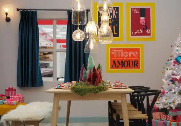 Elegant pendant lighting over festive table setting in holiday-themed room.