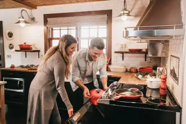 Modern kitchen with two people cooking under Fritz Fryer Lighting UK.