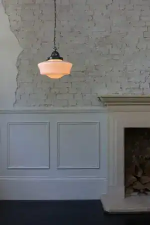 Elegant pendant light hanging from a textured ceiling in a modern interior setting.