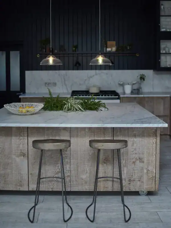 Modern kitchen island with pendant lighting and rustic stools in a contemporary kitchen.