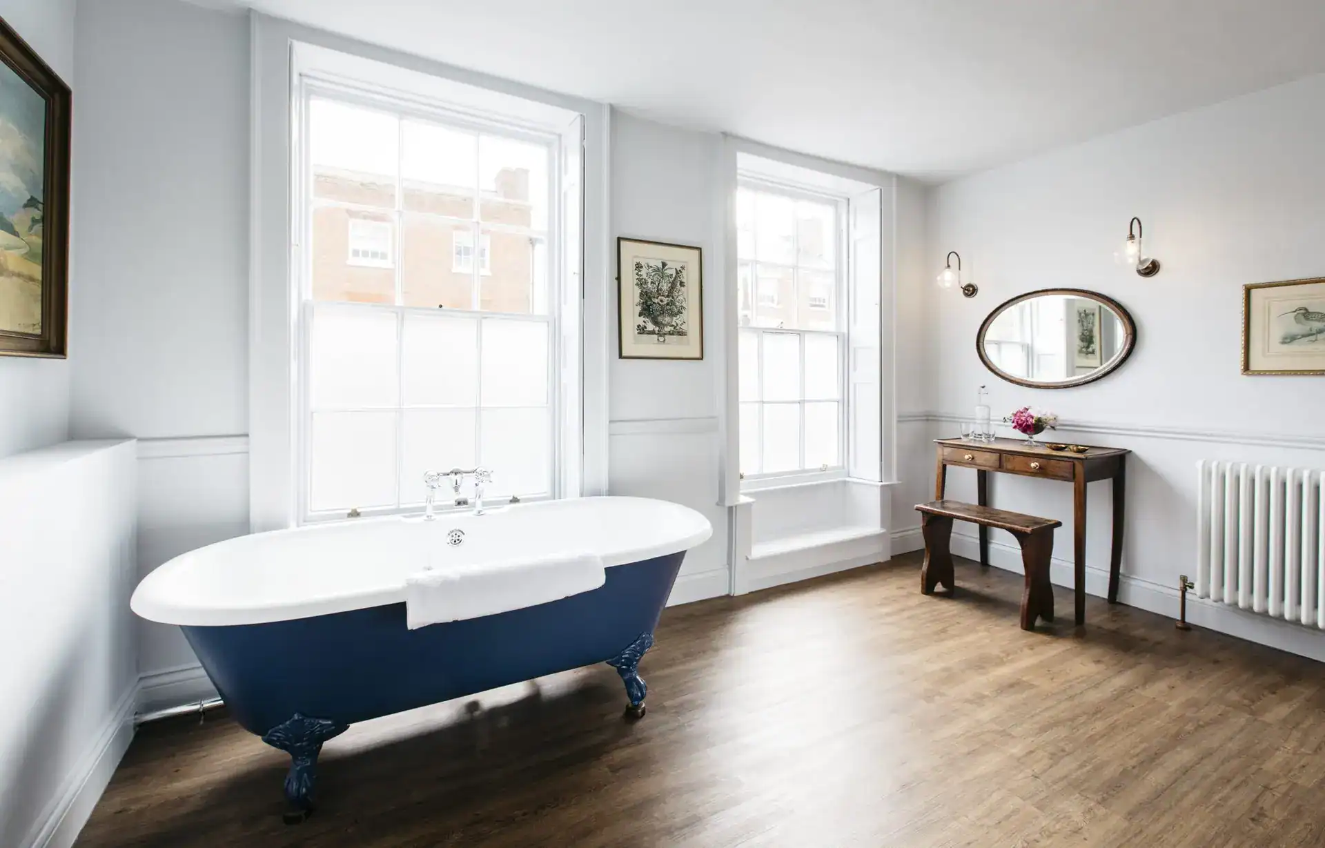 Elegant freestanding bathtub with clawfoot design in a bright, modern bathroom with large windows an.