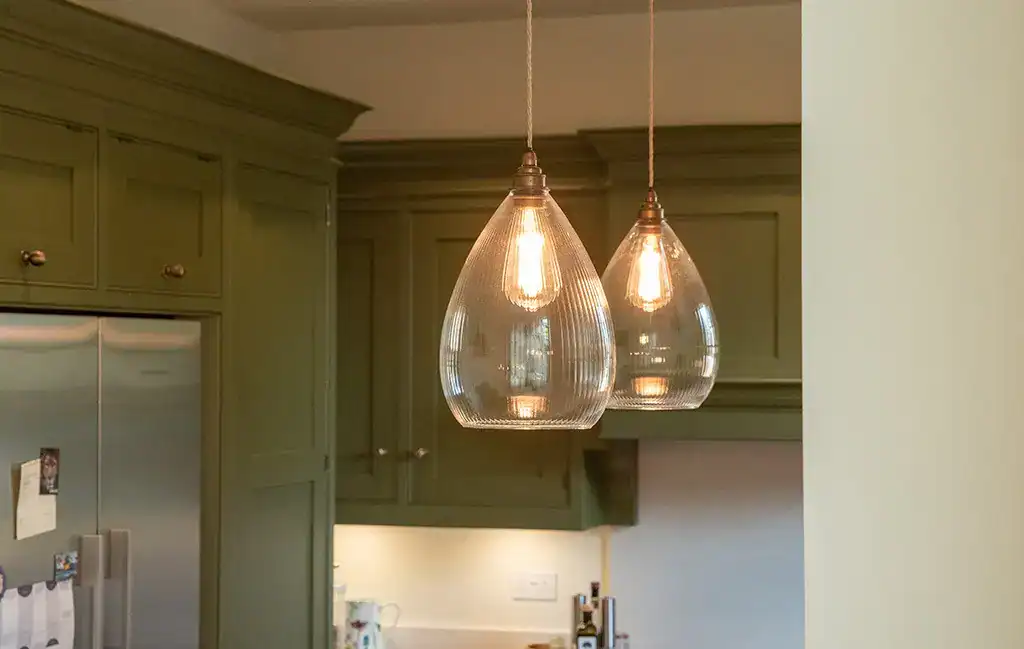 Elegant glass pendant lights over kitchen island.