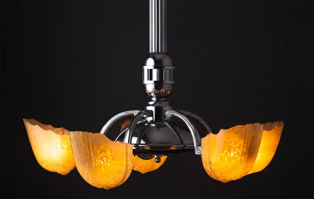Elegant chandelier with amber glass shades and chrome finish.