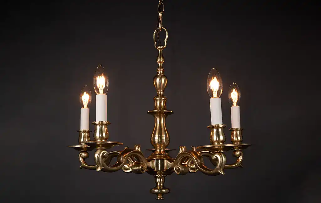 Elegant antique brass chandelier with five candle-style lights, perfect for classic interiors.