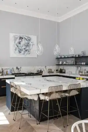 Pendant lights hanging above a marble kitchen island in a contemporary space.