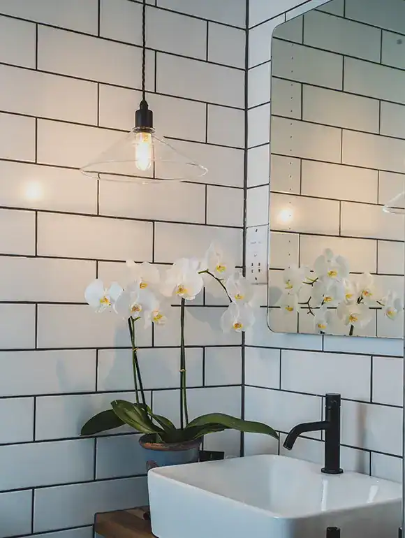Pendant light with exposed bulb in a contemporary bathroom setting.