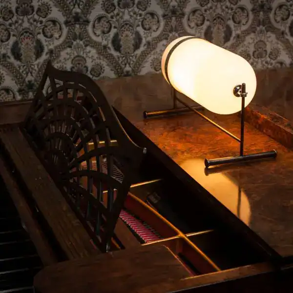 Stylish piano illuminated by a contemporary table lamp, creating a warm and inviting atmosphere.