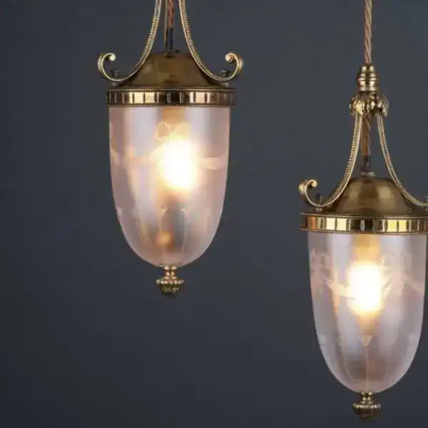 Vintage brass hanging lanterns with glass shades and ornate details.