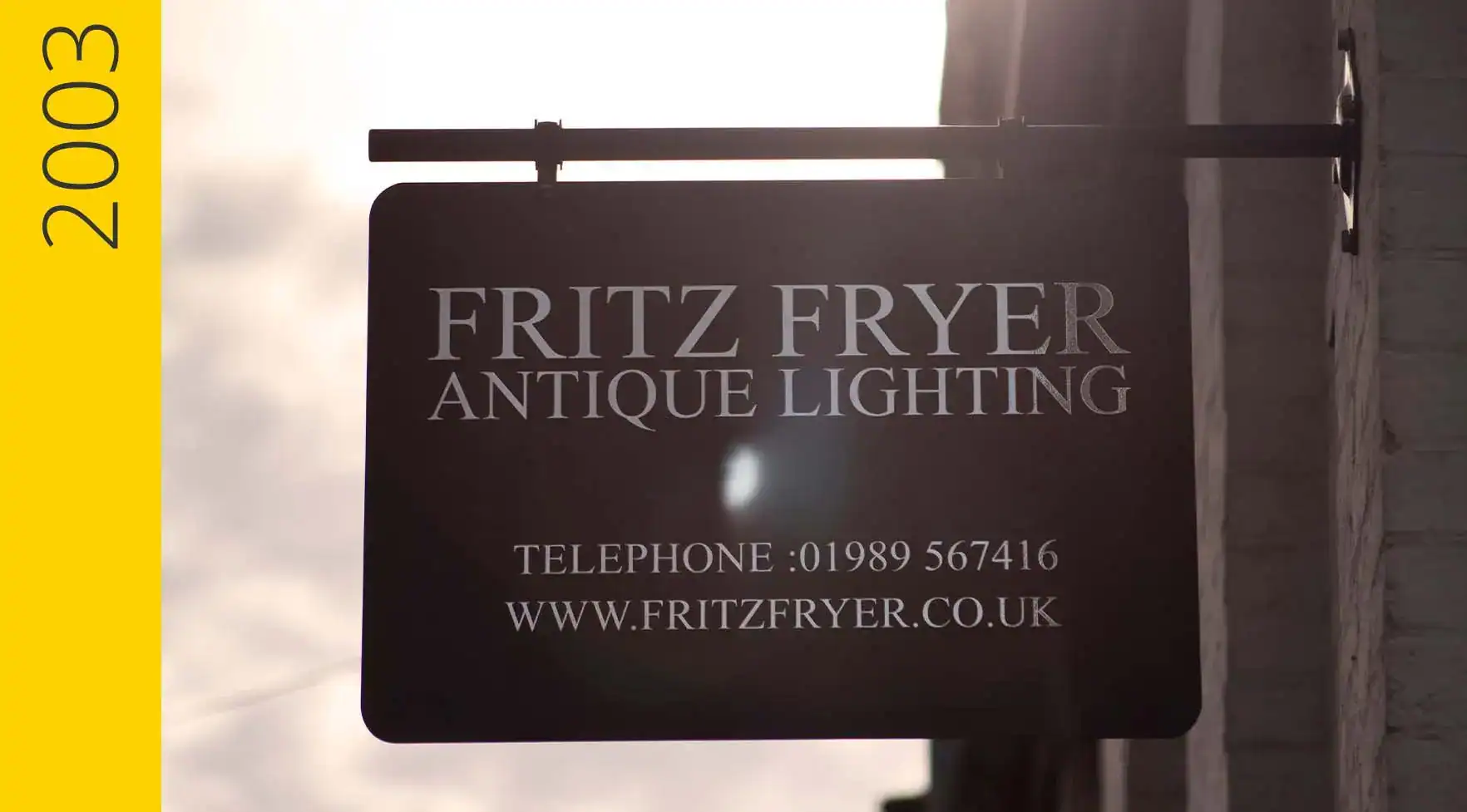 Fritz Fryer antique lighting shop sign with contact details in the UK.