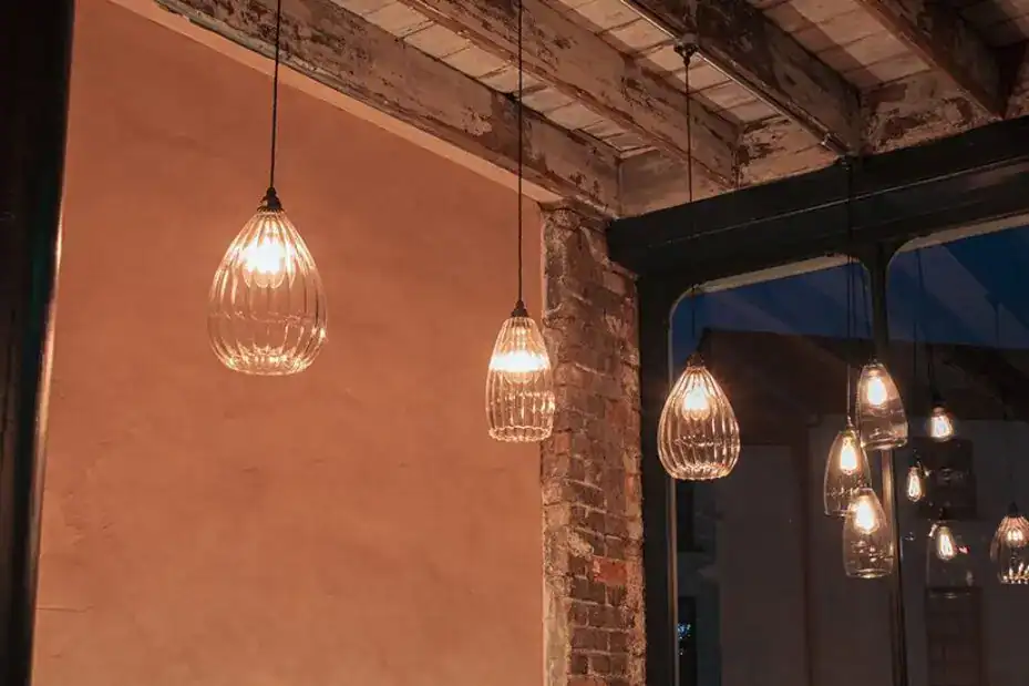 Elegant glass pendant lights hanging from an industrial ceiling.