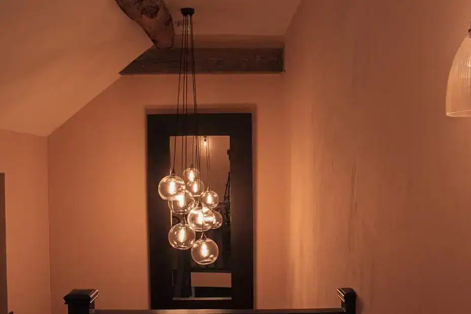 Pendant lighting fixture with multiple glass globes hanging in a warm, inviting room.