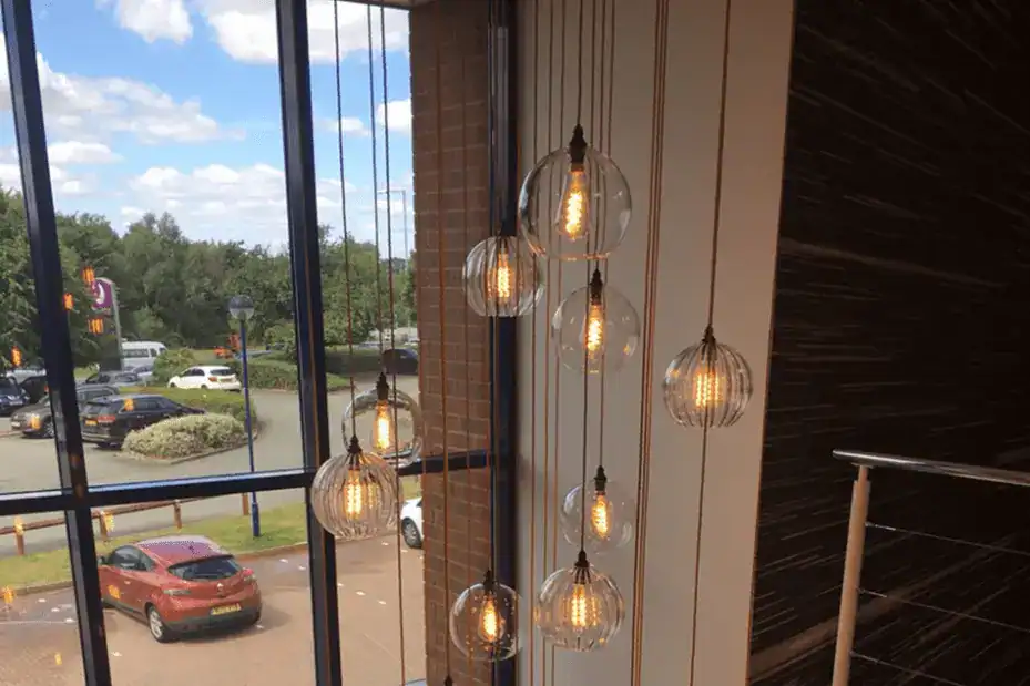 Elegant hanging pendant lights with exposed filament bulbs in a modern interior setting.