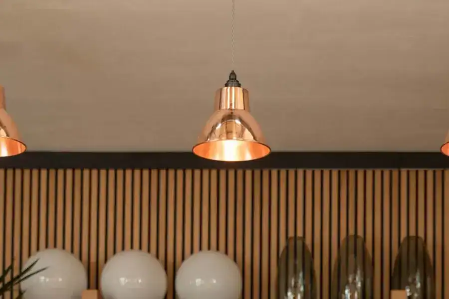 Copper pendant lights hanging from the ceiling with warm lighting effects.