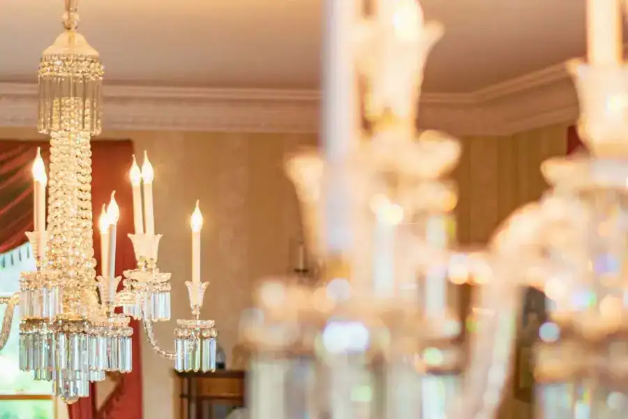 Elegant chandelier with multiple candles and crystal details in a sophisticated room.