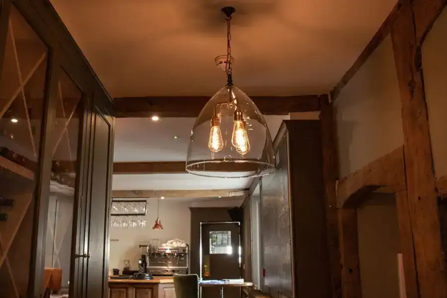 Modern pendant light with exposed filament bulbs in a stylish interior setting.