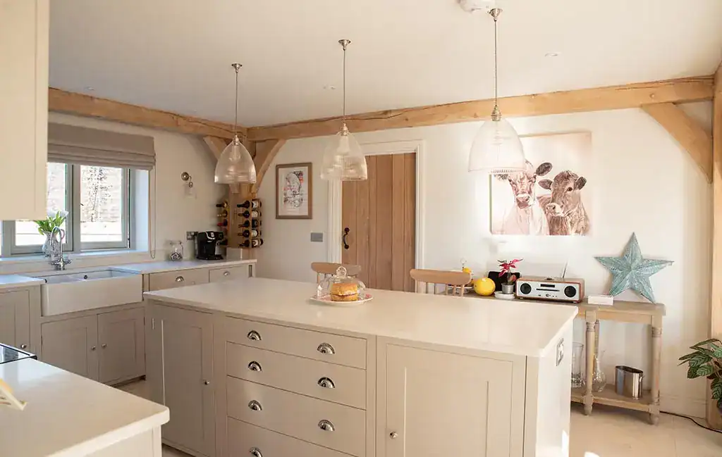 Pendant lighting over kitchen island with warm glow, wooden beams, and cosy decor in a contemporary.