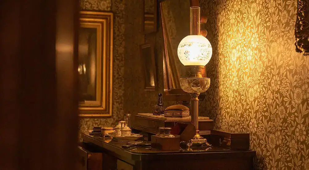 Vintage oil lamp with warm glow illuminating a traditional room interior.