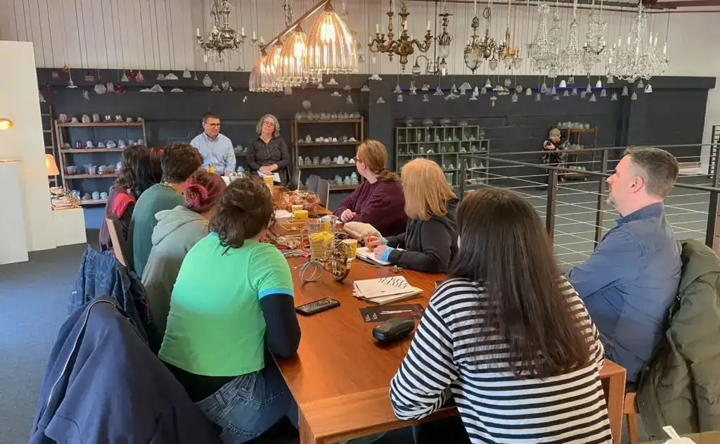 Modern lighting display with a group meeting in a showroom setting.