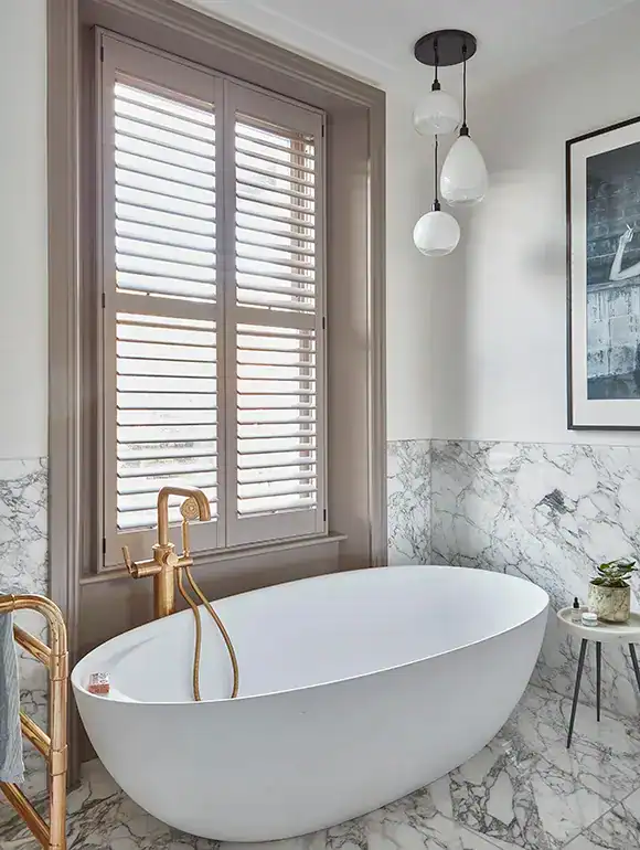 Modern freestanding bathtub with natural light and elegant decor in a stylish bathroom.
