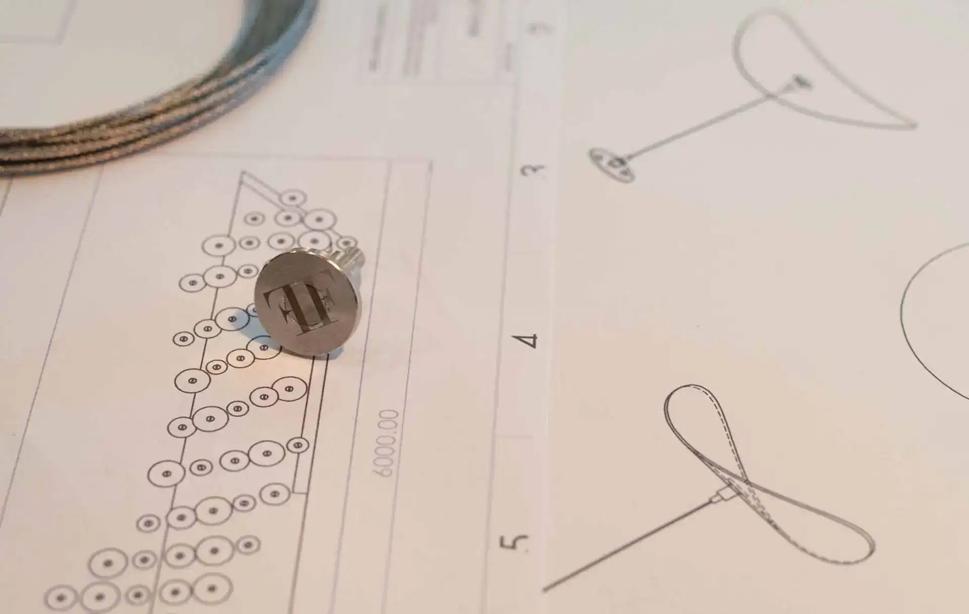 Lighting design blueprint with technical drawings and a small component on paper.