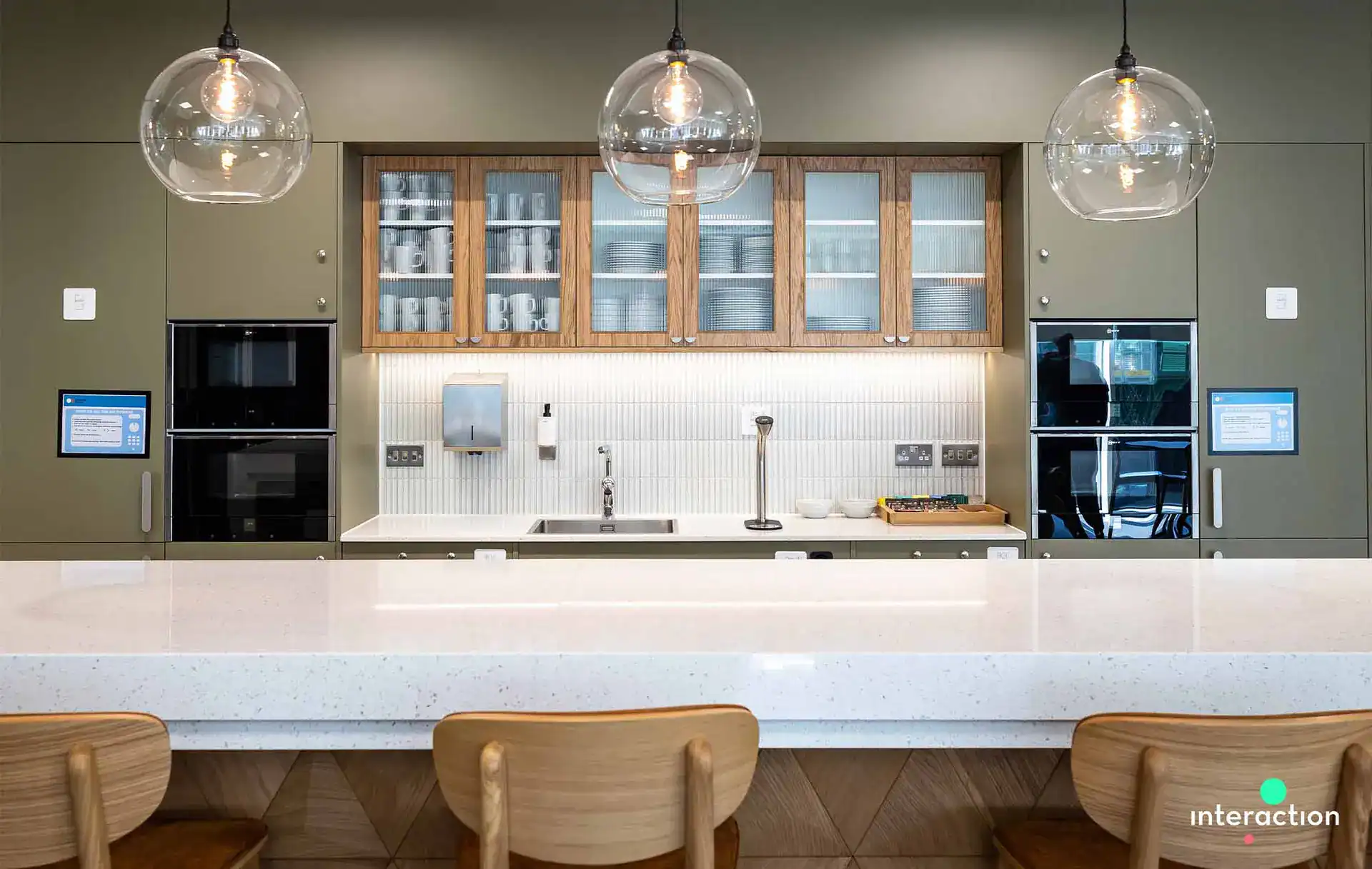 Pendant lights over kitchen island with glass globes and warm lighting.