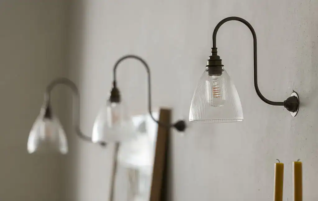 Industrial wall lighting with glass shades and black metal arms.