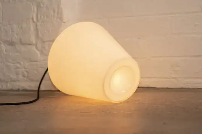 Modern cone-shaped table lamp with warm glow.